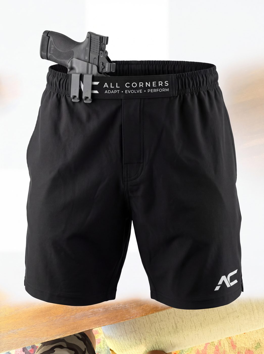 All Corners Shorts in black with a holstered firearm clipped to the patent-pending waistband strap